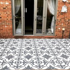 a black and white tiled patio with glass doors