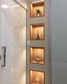 three shelves with various items in them on the wall next to a shower stall door