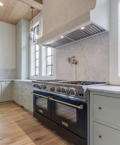 an image of a kitchen setting with two ovens and a stove top in the middle