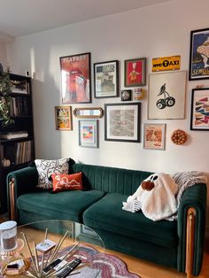 a living room filled with furniture and lots of framed pictures on the wall above it