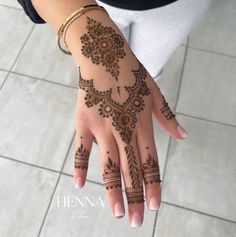 a woman's hand with henna tattoos on it