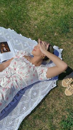 a woman laying on top of a white blanket