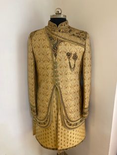 This Royal look sherwani comes in jacket . Groom wear this beige raw silk and brocket double layer designer sherwani. Nice features with thread,zari,embroidary,beads,zardosi and sequins on the attire, stand collar, nice design on shoulder,chest, necklace and on sleeves . Comes with matching bottom. Colour options available. Customisation available. WhatsApp me for customisation. Unstitched Beige Sherwani With Naqshi Detailing, Beige Raw Silk Sherwani With Dabka, Beige Sherwani With Resham Embroidery For Transitional Season, Beige Sherwani With Resham Embroidery, Fitted Raw Silk Sherwani With Naqshi Details, Fitted Raw Silk Sherwani With Naqshi, Traditional Beige Raw Silk Sherwani, Beige Sherwani With Zari Work, Traditional Drape, Unstitched Beige Sherwani With Zari Work