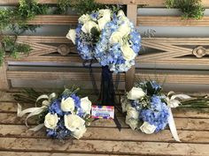 blue and white flowers are arranged on a bench