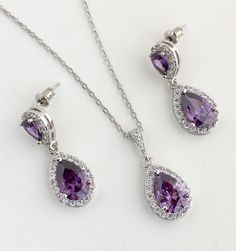 Super sparkly purple amethyst rhodium plated cubic zirconia bridal set includes : # Earrings feature a teardrop with pear cut purple amethyst cubic zirconia center surrounded by tiny round zirconia crystals. Teardrop dangles from purple cubic zirconia teardrop ear stud. Total length of the earrings is 2.9 cms. #Necklace pendant featuring a teardrop with pear cut purple amethyst cubic zirconia center surrounded by tiny round zirconia crystals and dangles from cubic zirconia bail. Length of the rh Elegant Purple Jewelry Sets For Formal Occasions, Formal Purple Crystal Jewelry Sets, Purple Teardrop Necklace For Wedding, Purple Crystal Jewelry Sets For Formal Occasions, Elegant Purple Jewelry Sets For Wedding, Elegant Purple Bridal Necklace For Wedding, Purple Crystal Jewelry Sets For Wedding, Rose Gold Bridal Jewelry, Bridesmaid Jewelry Set