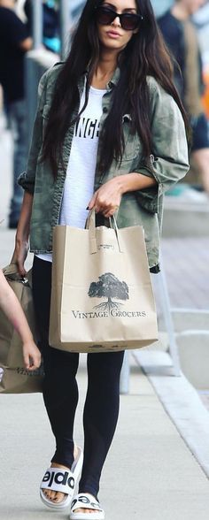 a woman walking down the street carrying shopping bags