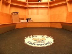 an empty room with shelves and a logo on the floor