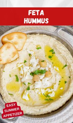 hummus in a bowl with crackers on the side