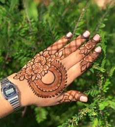 a woman's hand with henna on it and a watch in the palm