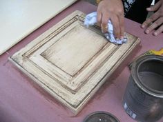 a person is using a rag to clean the wood grains on a door frame