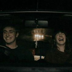 two people sitting in the back seat of a car with their mouths open and laughing