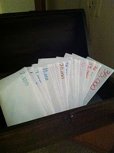 a wooden box filled with lots of white envelopes on top of a carpeted floor