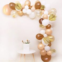 the balloon arch is decorated with gold and white balloons