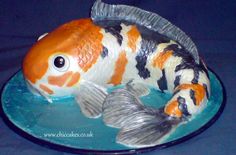 a gold and white fish sitting on top of a blue plate