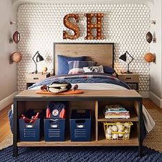 a bed room with a neatly made bed and lots of storage under the letters above it