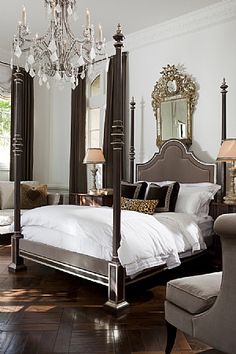 a bedroom with four post bed and chandelier