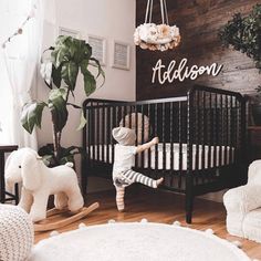 a baby in a crib playing with the rug and rocking chair next to it