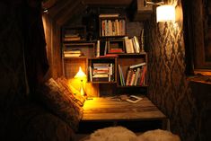 a room with bookshelves and a table in it, lit by a lamp