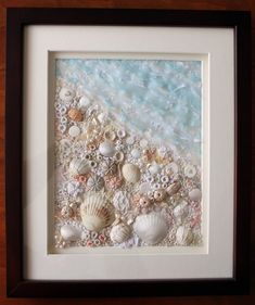 an image of seashells on the beach framed in a white frame with brown trim