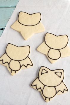 four decorated cookies sitting on top of a table