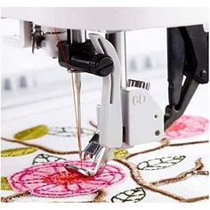 the machine is working on an embroidered flower design with scissors and thread in it's holder