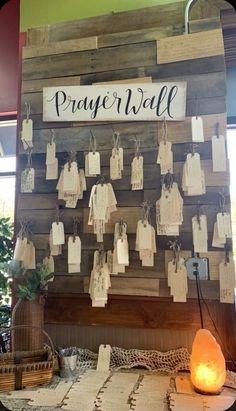 a wooden wall with many tags hanging from it's sides and the word prayer hall written on it