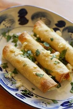 some food that is on a blue and white plate with green garnishes