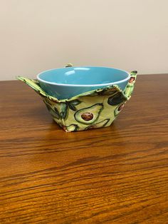 a blue bowl sitting on top of a wooden table next to a brown countertop