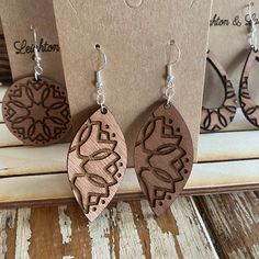 three wooden earrings are on display for sale