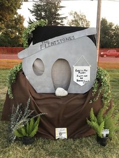 a house made out of cement with plants growing on it's sides and a sign that says flintstones