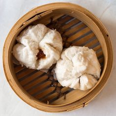 two dumplings in a bamboo basket on a table