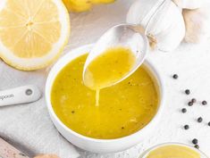 a spoon is being drizzled over a bowl of soup