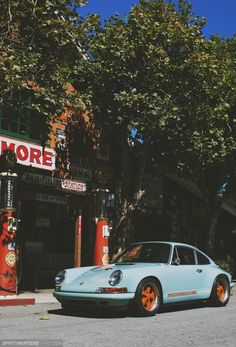 a blue car parked in front of a gas station