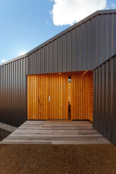 a large metal building with wooden doors on the front and side walls that are open