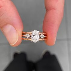 a close up of a person's hand holding a ring with a diamond on it