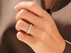 a woman's hand wearing a diamond ring