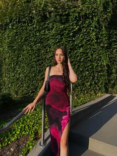 a woman in a long dress is walking down the stairs with her hand on her head