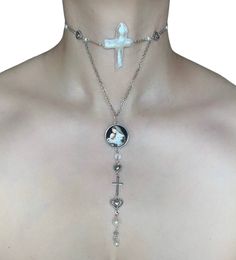 The Blessed Mother Choker 🖤 This stunning choker is made using a gorgeous cultured cross pearl, silver chains, silver heart beads, faux pearls, a silver heart and cross connector, and a Virgin Mary cabochon charm. The combination of materials and colors creates a truly eye-catching and eclectic look that is sure to turn heads. 🤍 Whether you're dressing up for a special event or just running errands around town, the Quirky Rosary Choker is the perfect way to add a touch of personality to your outfit. 🖤 Only one available as I like to make one of a kind pieces so that you have a unique, standout, rare, special piece that you can't find anywhere else. Care Instructions: Keep your jewellery away from water, oils, perfumes and make sure to remove before showering and sleeping in order to kee Rosary Choker, Heart And Cross, Chains Silver, Virgin Mary Necklace, Necklace Outfit, Pearl Heart, Silver Chains, Blessed Mother, Gothic Jewelry