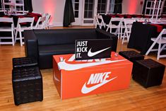 an orange and white box sitting on top of a hard wood floor next to chairs