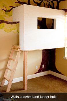 a child's bedroom with a tree painted on the wall and ladder to the bottom