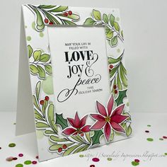 a christmas card with holly and poinsettis on it, next to confetti