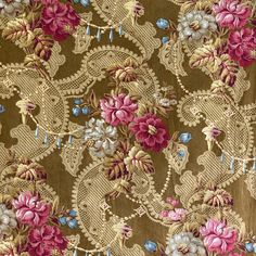 an intricately designed fabric with pink and blue flowers on brown background, closeup