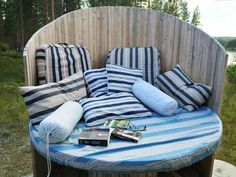 an outdoor bed with pillows and books on it