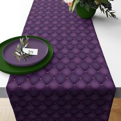 a purple table runner with green plates and flowers