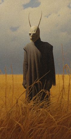 a man standing in the middle of a field with a horned mask on his head