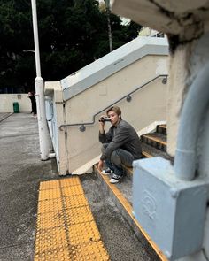 a man sitting on the steps taking a photo