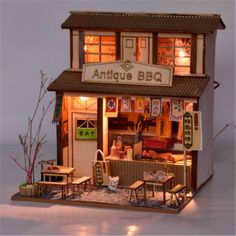 a small doll house with furniture and lights on it's front porch, in the evening