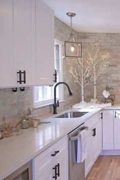 a kitchen with white cabinets and marble counter tops is seen in this image from the doorway