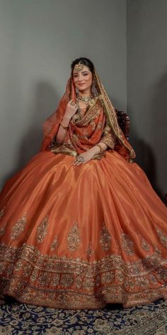 a woman in an orange dress sitting on a chair