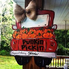 an orange truck with pumpkins painted on it and a bow hanging from the front